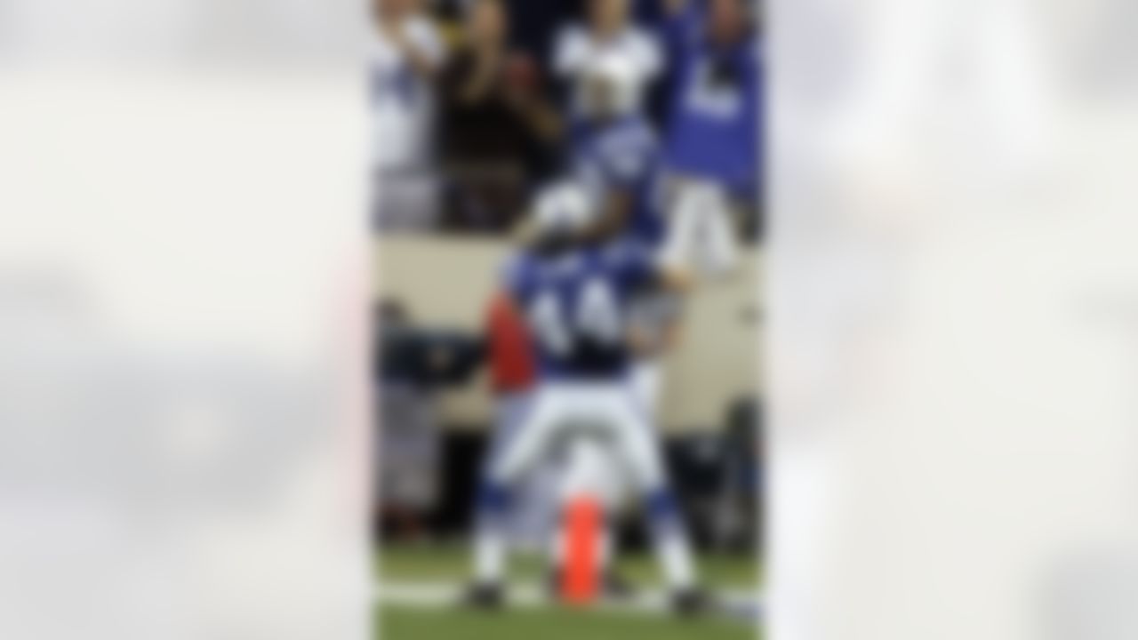 Indianapolis Colts receiver Marvin Harrison, top, jumps into the arms of teammate Dallas Clark after scoring an 80-yard touchdown on the first play from scrimmage during the first quarter against the Pittsburgh Steelers in Indianapolis Monday, Nov. 28, 2005. (AP Photo/Michael Conroy)