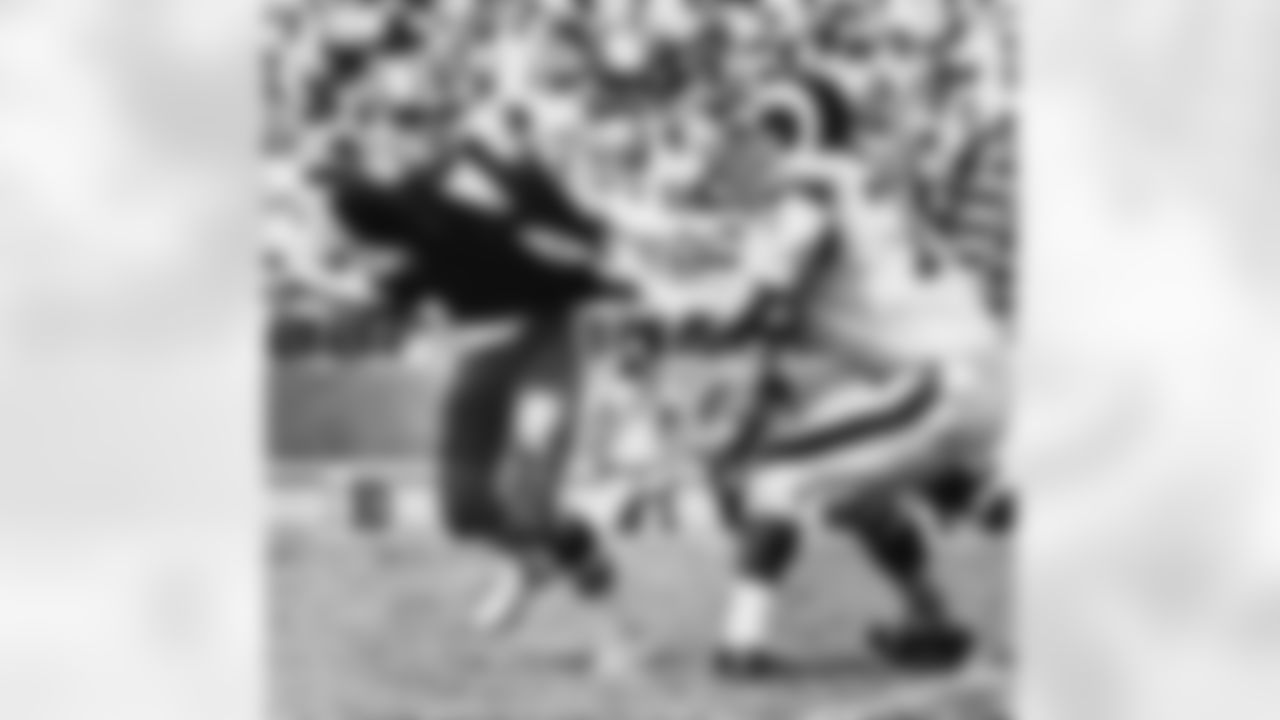 New Orleans Saints quarterback Archie Manning, left, comes down with a shirt-tackle by the Rams' Merlin Olsen in Los Angeles on Sept. 18, 1972. (AP Photo)