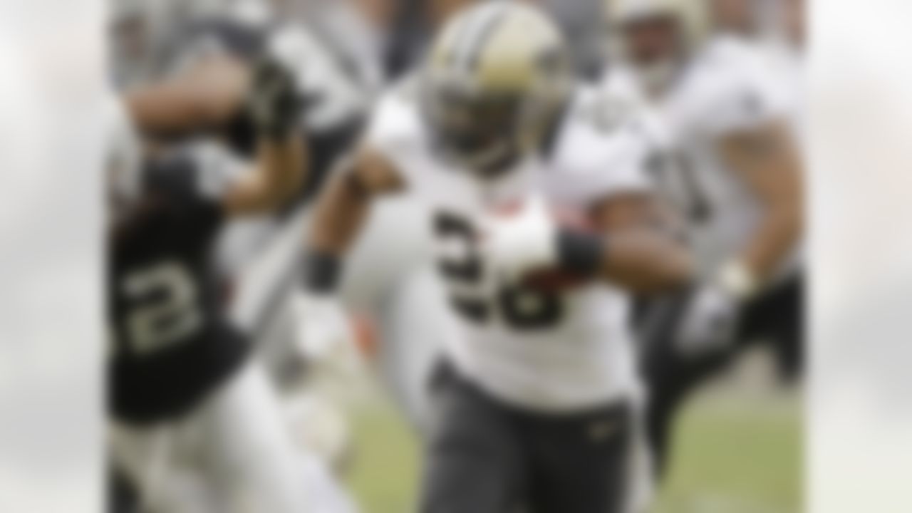 New Orleans Saints running back Mark Ingram carries the ball on a 27-yard touchdown run during the third quarter of an NFL football game against the New Orleans Saints in Oakland, Calif., Sunday, Nov. 18, 2012. At left is Oakland Raiders outside linebacker Philip Wheeler. (AP Photo/Ben Margot)