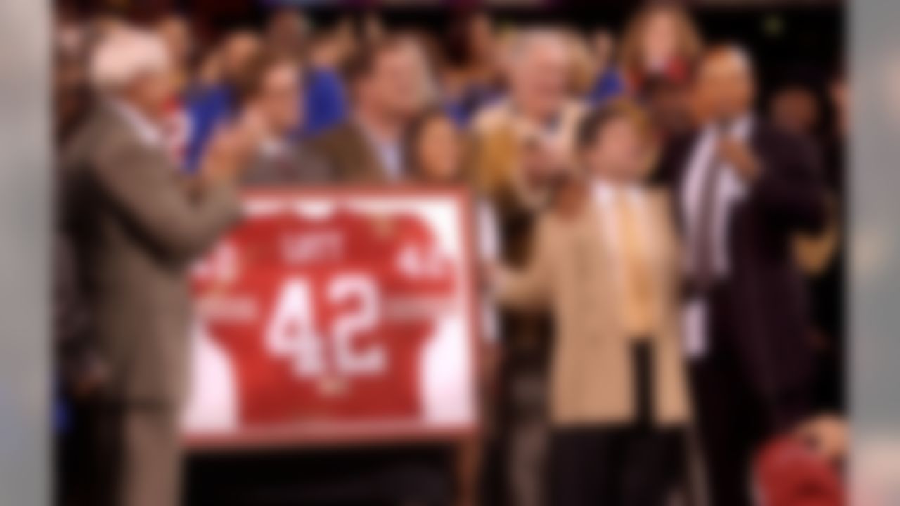 Former San Francisco 49ers safety Ronnie Lott, right, has his jersey retired during half time during the 49ers game against the Pittsburg Steelers, Monday, Nov. 17, 2003 in San Francisco. Next to Lott is former 49ers owner Eddie DeBartolo Jr. and former coach Bill Walsh, far left. (AP Photo/Paul Sakuma)