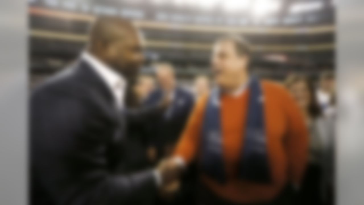 Former Dallas Cowboys player and Hall of Famer Emmitt Smith, left, greets New Jersey Gov. Chris Christie, right, on the field as teams warm up an NFL football game between the Indianapolis Colts and Dallas Cowboys, Sunday, Dec. 21, 2014, in Arlington, Texas. (AP Photo/Brandon Wade)