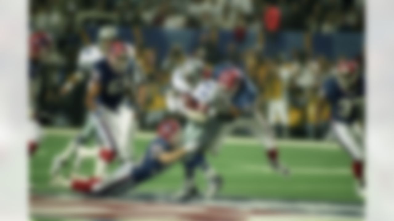Dallas Cowboys running back Emmitt Smith (22) carries Buffalo Bills safeties Henry Jones (20) and Mark Kelso (38) for a few yards during Super Bowl XXVIII, a 30-13 Cowboys victory on January 30, 1994, at the Georgia Dome in Atlanta, Georgia. (National Football League)