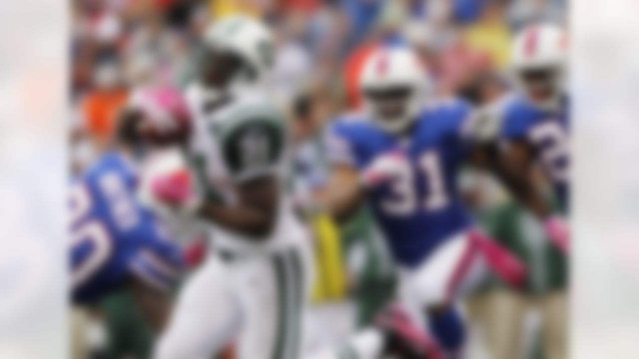 New York Jets running back LaDainian Tomlinson (21) runs for a touchdown past Buffalo Bills defenders Donte Whitner (20), Jairus Byrd (31) and Drayton Florence during the second half of an NFL football game in Orchard Park, N.Y., Sunday, Oct. 3, 2010. The Jets won 38-14. (AP Photo/Mike Groll)