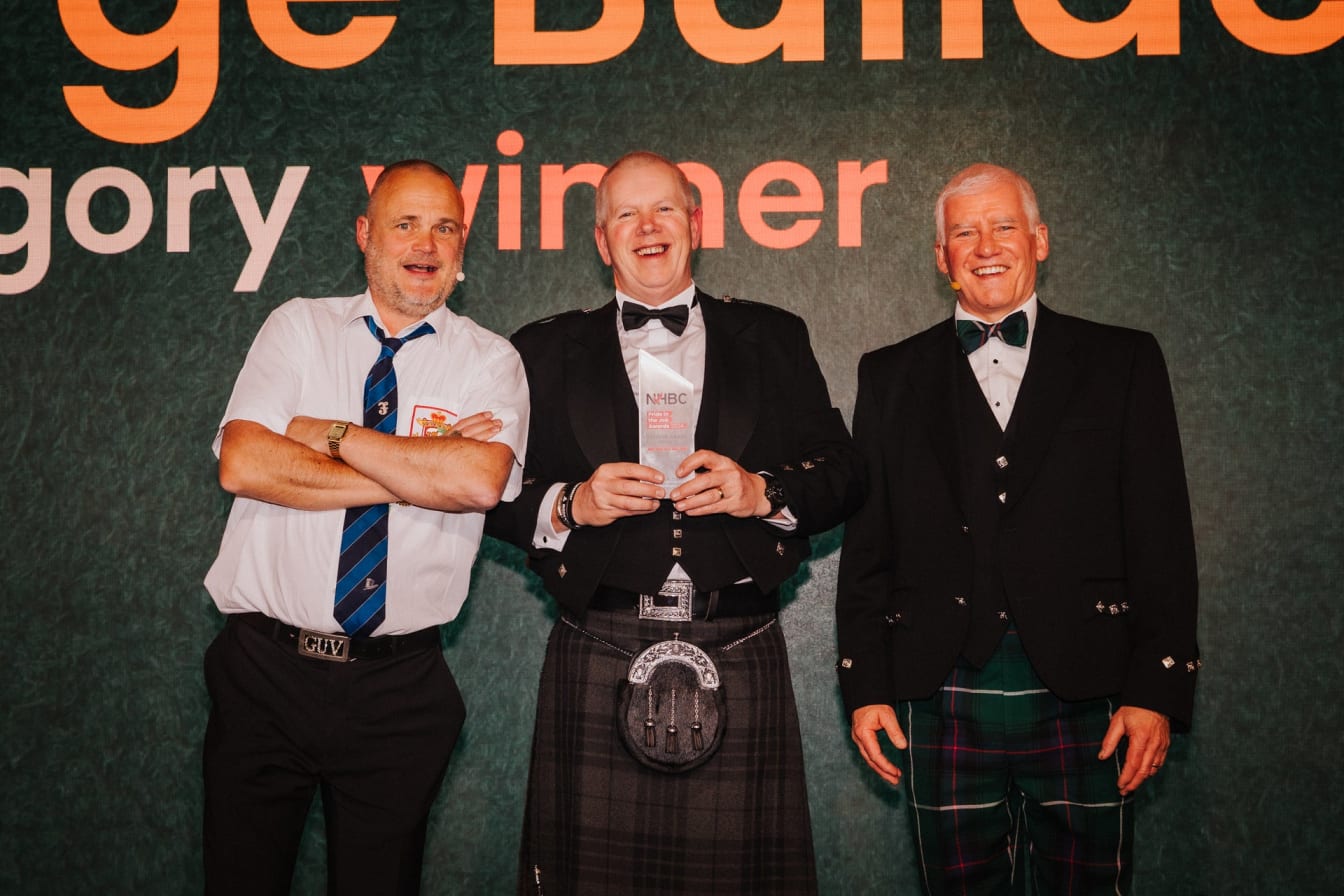 David holding an awards and smiling at the camera