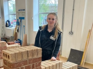Leeanna smiling at the camera with her wall