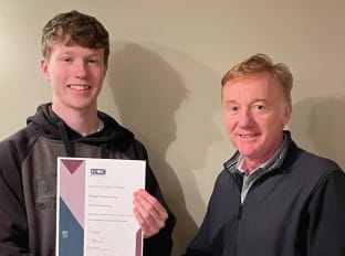 two guys smiling at the camera and holding a certificate
