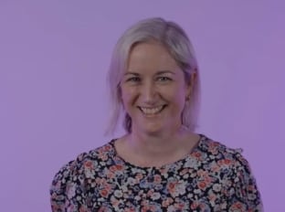 Madeleine Warsop smiling at the camera on a purple background