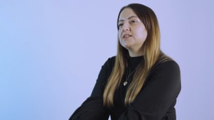Sarah Tarn talking to the camera on a purple background