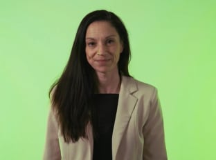 Hazel talking to the camera on a green background