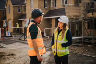 NHBC building inspector speaking with a construction worker on a residential development site.