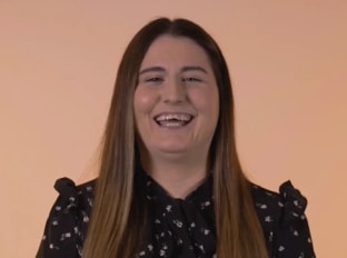 Laura Venn smiling at the camera on an orange background