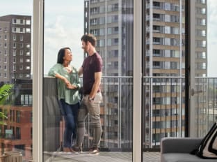 a couple on a balcony of a high rise building