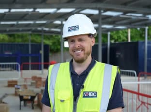 a man wearing safety clothes smiling in front of the camera