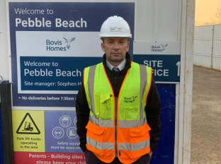 Stephen smiling at the camera and wearing safety clothes