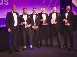 a photo of some winners in suits at the pij awards