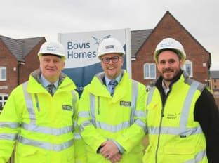 Three people in site safety clothing smiling at the camera