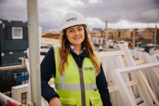 Sarah Tarn in ppe smiling at the camera whilst on site