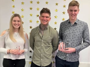 two apprentices smiling at the camera with their awards with the uks fastest bricklayer and influencer, charlie collison