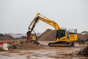 a yellow digger on a brownfield site