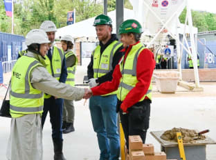 hrh the princess royal shaking hands with a female bricklaying apprentice