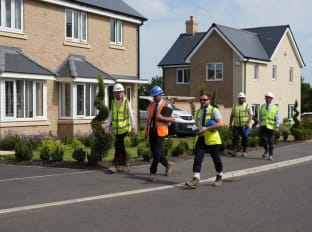 nhbc regional directors walking through a completed new build site in high vis safety clothing