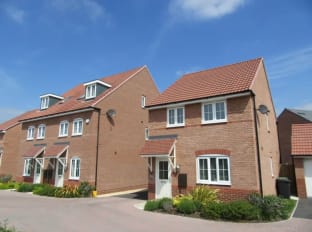 a photo of a row of red brick houses on a sunny day