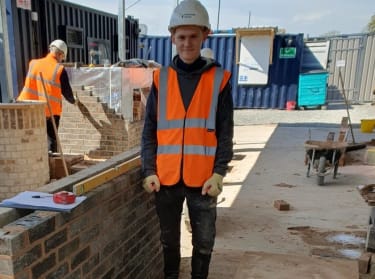 a man wearing safety clothes smiling at the camera