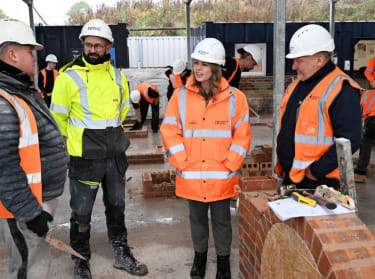 north east mayor in high vis safety clothing talking to bricklaying apprentices