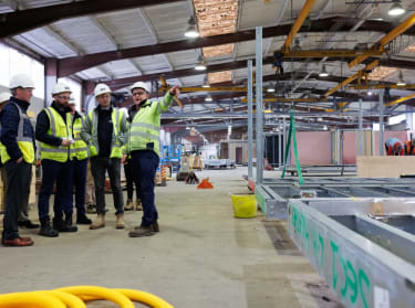 a photo of a team from nhbc visiting a factory