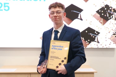 Ryley McBride smiling at the camera holding his certificate