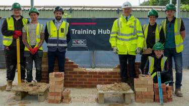 nhbc ceo steve wood with apprentices at the cambridge training hub smiling at the camera