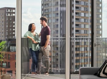 a couple on a balcony of a high rise building