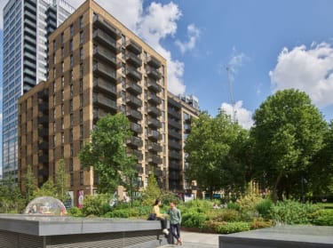 a photo of two blocks of new build flats in the sunshine