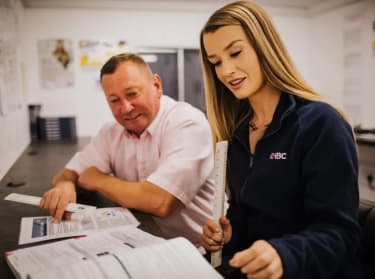 two nhbc staff members reviewing documents
