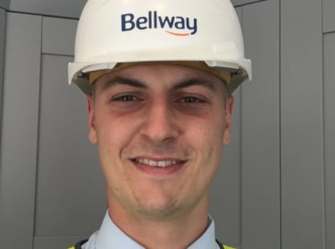 a man wearing a white helmet smiling at the camera