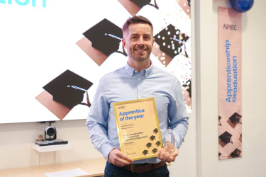 Matthew Griffiths smiling at the camera holding his certificate