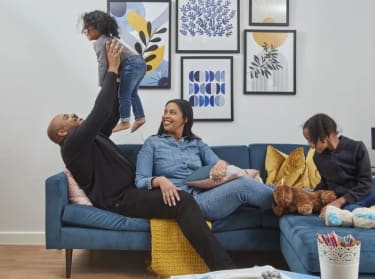a family of four sat on the sofa playing