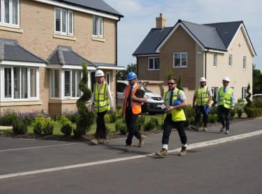 nhbc regional directors walking through a completed new build site in high vis safety clothing