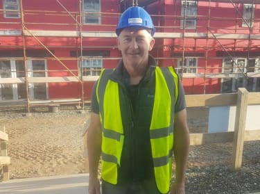 A man with hi-vis jacket standing on a construction site