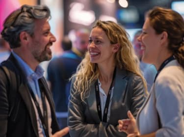 three people networking and smiling whilst at an event