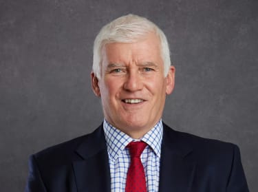 Steve Wood, Chief Executive Officer of NHBC, smiling at the camera on a grey background