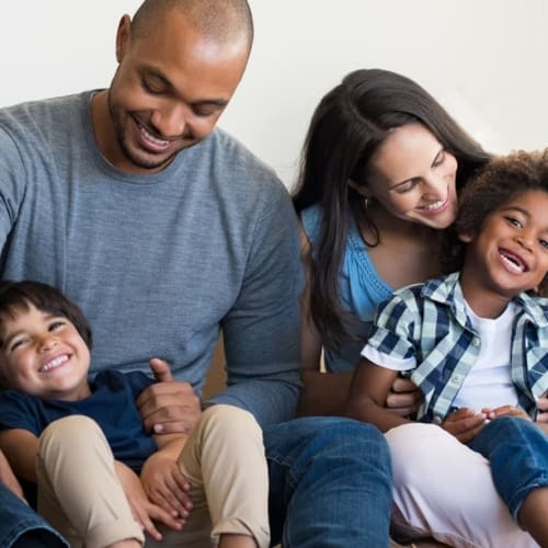 Family of four sat on the floor smiling
