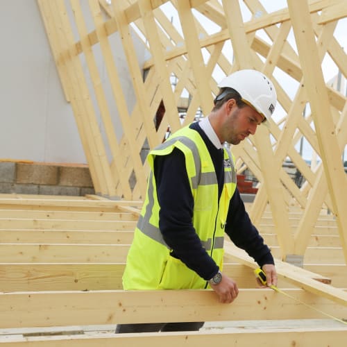 NHBC staff member inspections roof joints while wearing yellow high vis vest