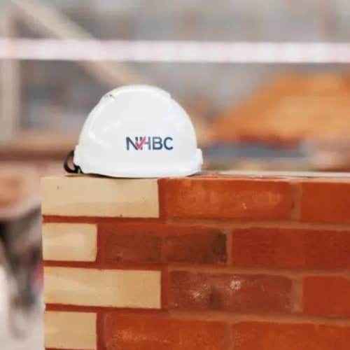 NHBC hard hat on brick wall