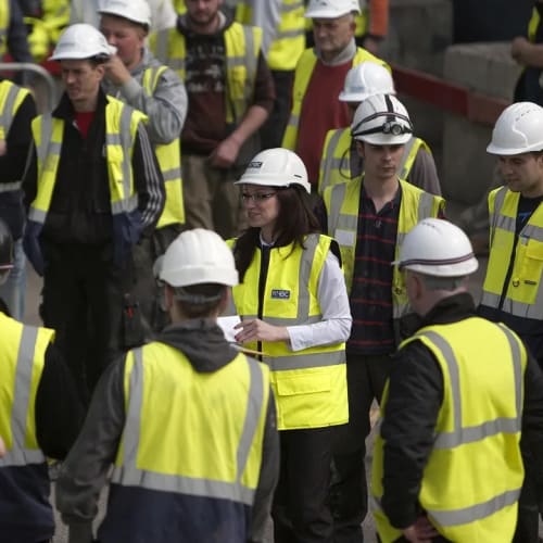 Group of NHBC team with safety jackets and hard hats on site