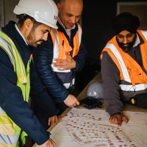 inspectors reviewing a site plan in full ppe
