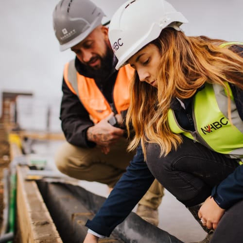 A man and a woman inspecting some brickwork