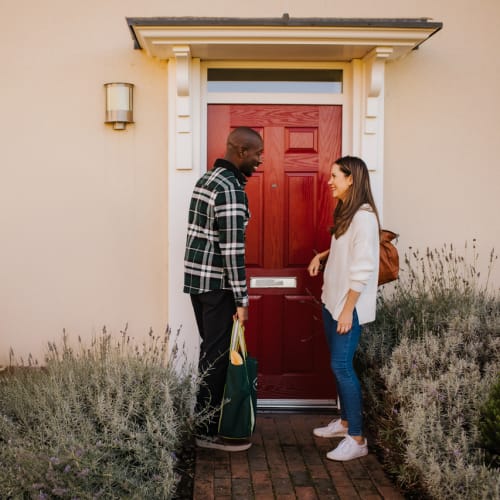 Homeowners meeting outside a shared ownership new-build home.