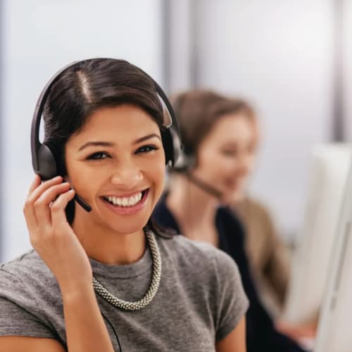 Woman smiling with headset on at computer