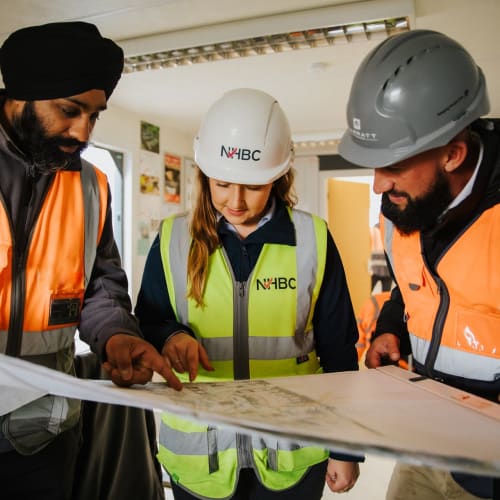three inspectors reviewing site plans in full ppe
